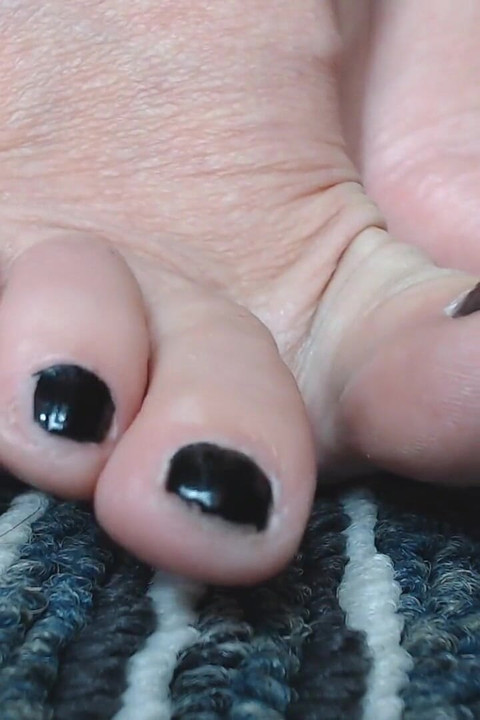 เล่นเล็บเท้าสีดําแบบโคลสอัพ