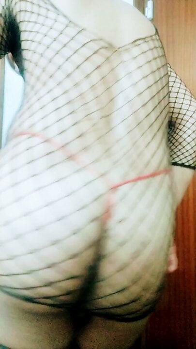 Bailando cumbia muy cachonda en mi casa con medias de rejilla y tanga que perfore para que salga mi pollla