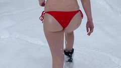 Culo di bolla in bikini che cammina nella neve