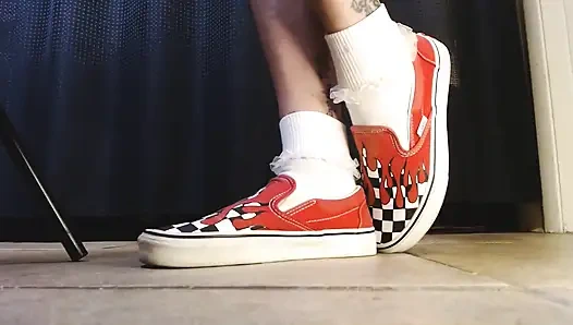 Cewek dengan kaus kaki putih dengan kaus kaki vans flame sneakers lagi asik main sepatu