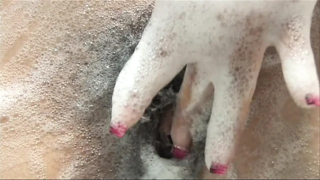 Caressing her sexy body in a bath