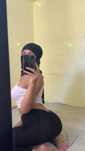 Arab Hijab Goddess Sits On Bed Teasing Fans While Arching Her Back And Showing Off Her Butt