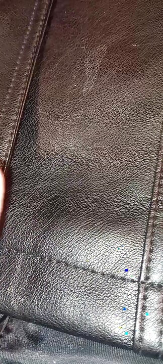 Ejakulerer på fôret på den svarte skinnfrakken hennes