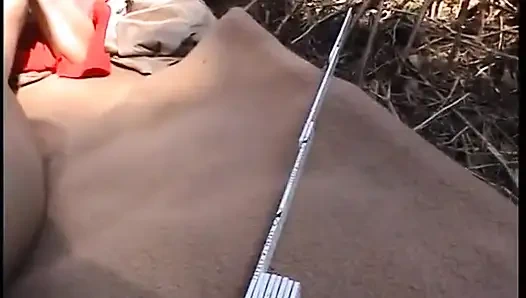 Redhead chick plays with her pussy outdoors