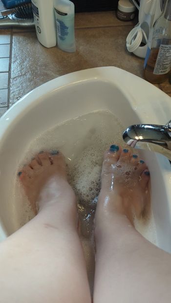 Feet getting soapy and wet.