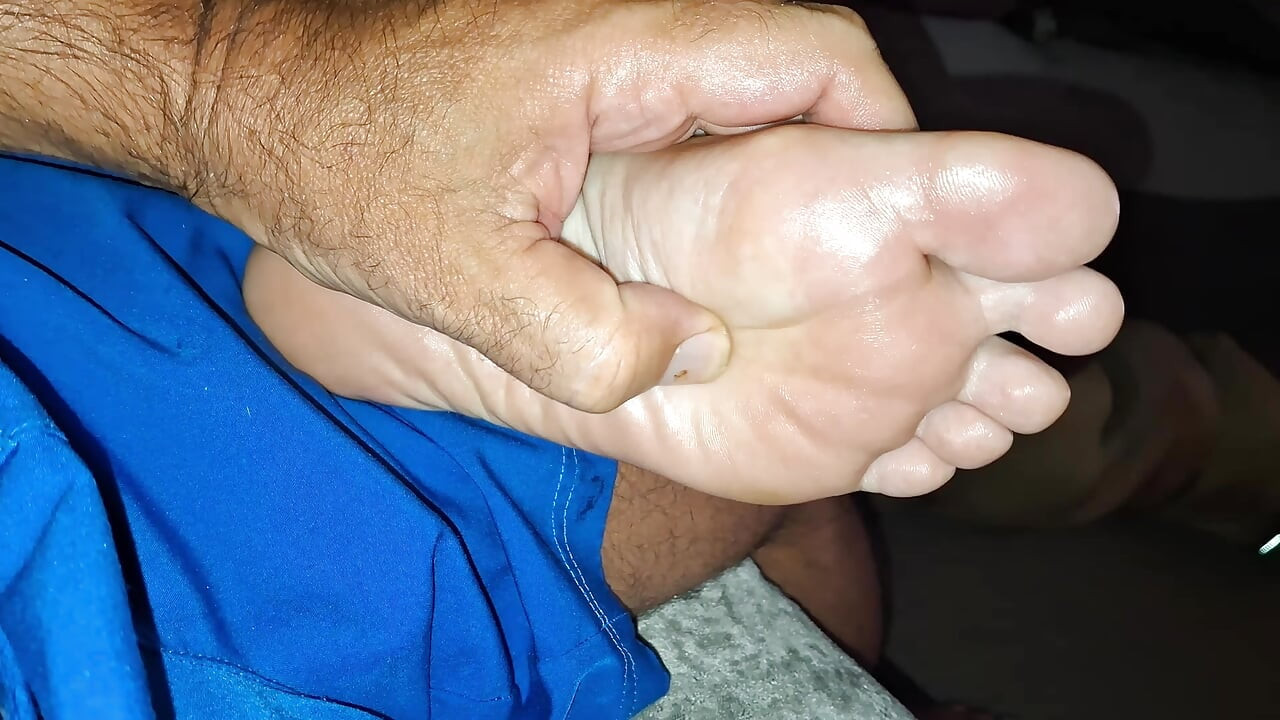 Giving her  a soft foot rub and massage on the couch