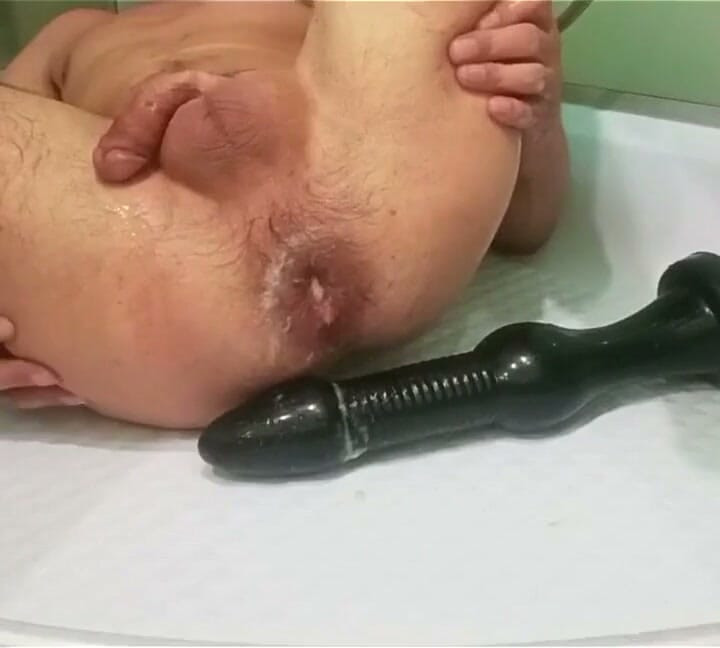 Estou deitada no chuveiro me fodendo com um consolo enorme.