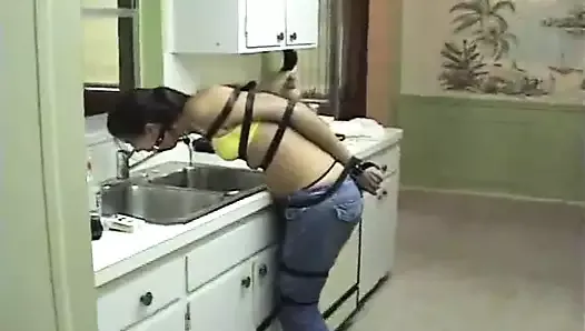 Tied-up girl hops to kitchen to drink from faucet