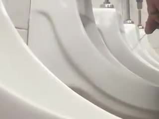 Beschnittener Mann pinkelt am Urinal