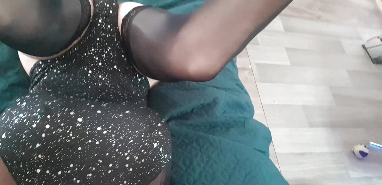 in a sexy black bodysuit and black stockings.