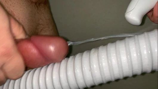 Un petit pénis se frotte et jouit sur le tuyau d'un aspirateur