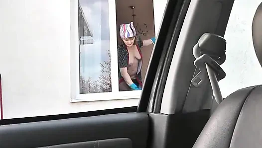 Nackt in der Öffentlichkeit. Taxifahrer beobachtet vom auto aus, wie eine frau in bademantel ohne höschen und bh in strümpfen ein wohnungsfenster wäscht