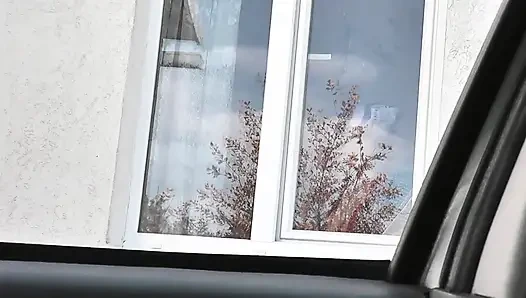Telanjang di depan umum. Sopir taksi menonton dari mobil sebagai wanita berjubah tanpa celana dalam dan bra sambil pakai stoking mencuci jendela apartemen