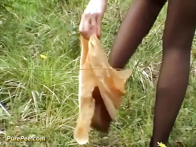 Senhora em calças de mijo ao ar livre