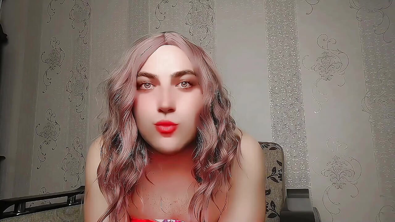 Razigrana sissy sjedi bočno na velikoj pahuljastoj stolici