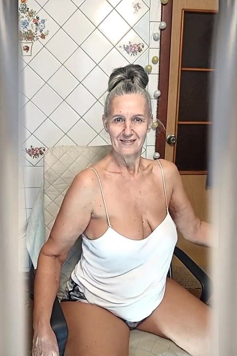 Gospodina veselă Lukerya Dansează în bucătărie și bea cafea în dimineața.