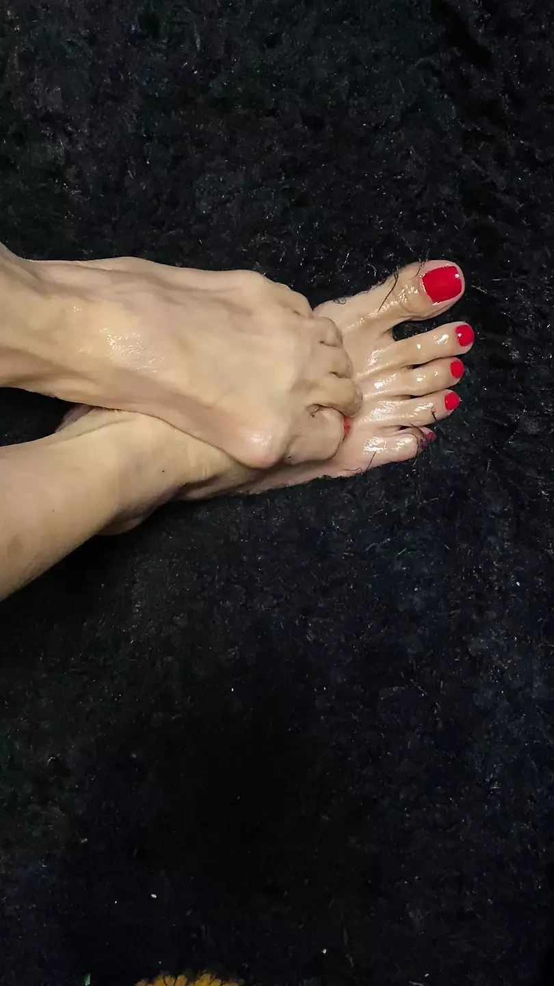 Oiled sexy tiny feet with red toenail polish