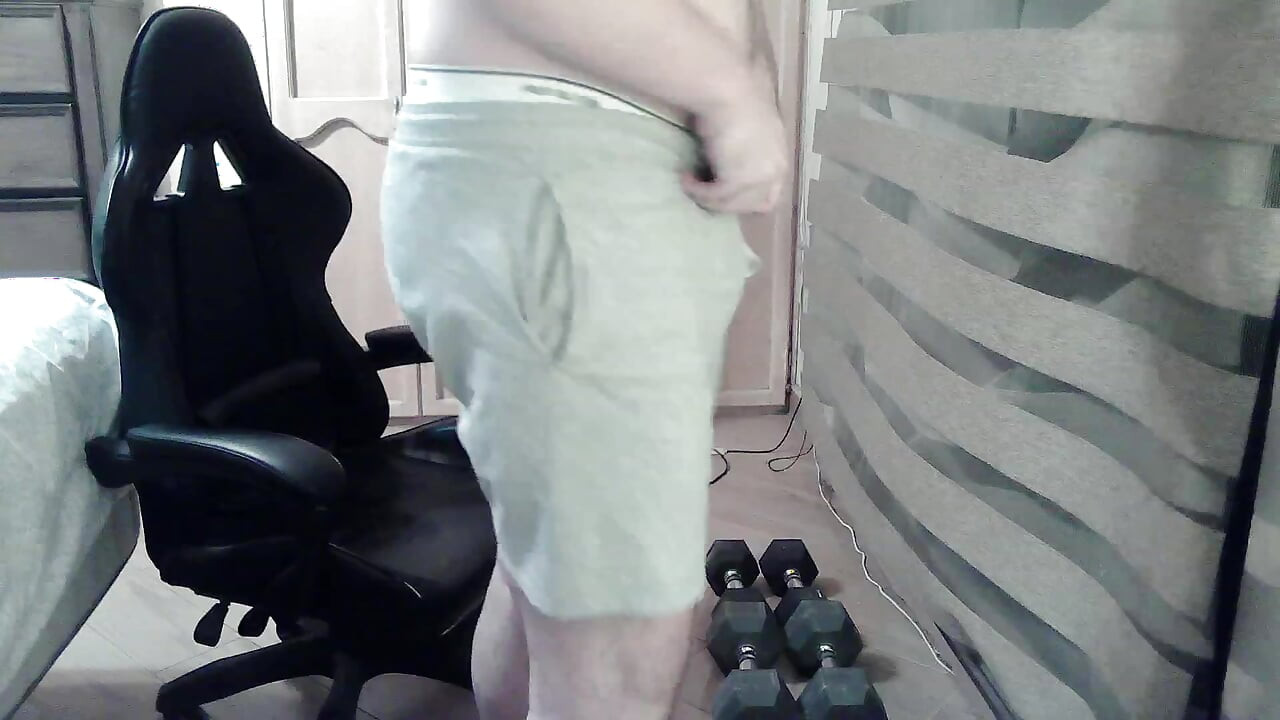 Muscular camboy flexes his muscles and squats