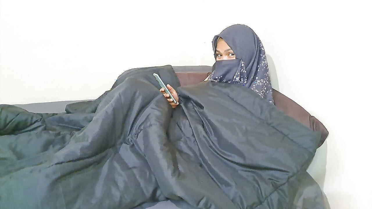 A woman in a hijab is masturbating on the sly.