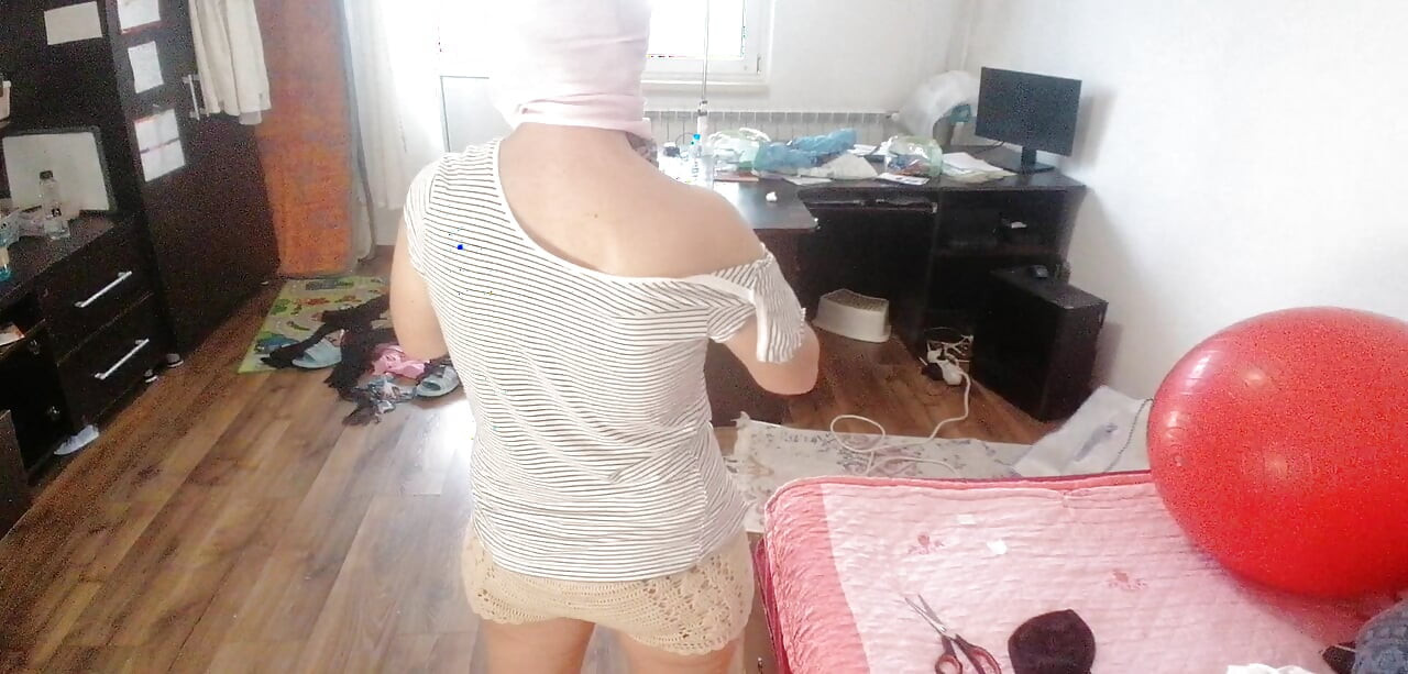 Amateur woman has fun trying on clothes and cutting them.