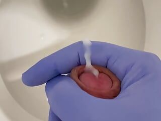 Doktor szarpie się lateksowymi rękawiczkami w toalecie w szpitalu