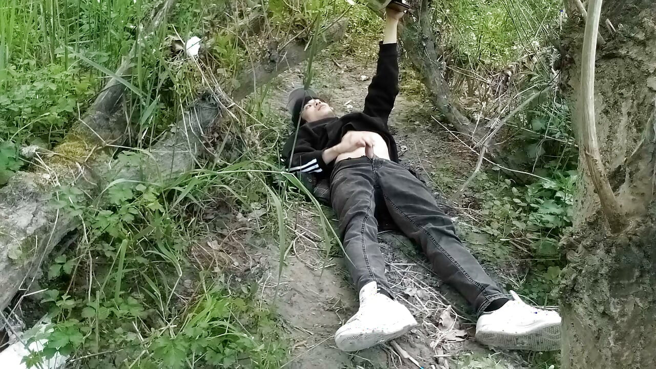 This gay twink sticks his cock through his fly to jerk off outside
