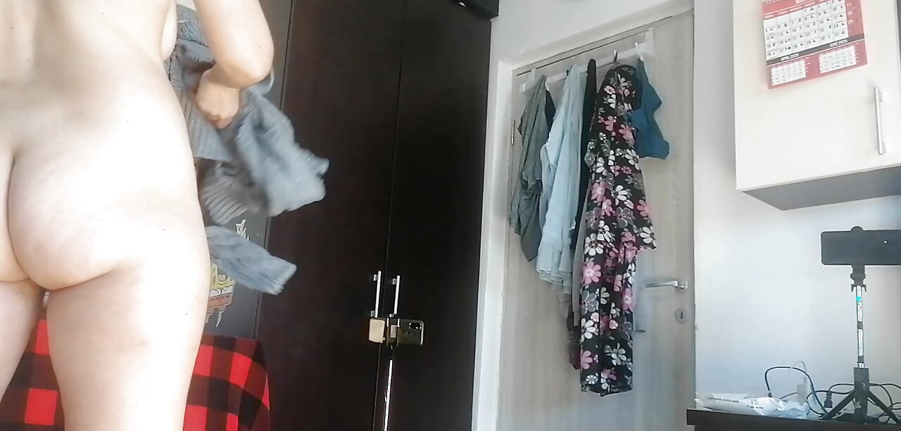 Amateur woman has fun trying on clothes and cutting them. Amateur woman vacuums naked in the house.
