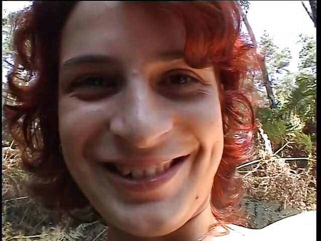 Redhead chick plays with her pussy outdoors