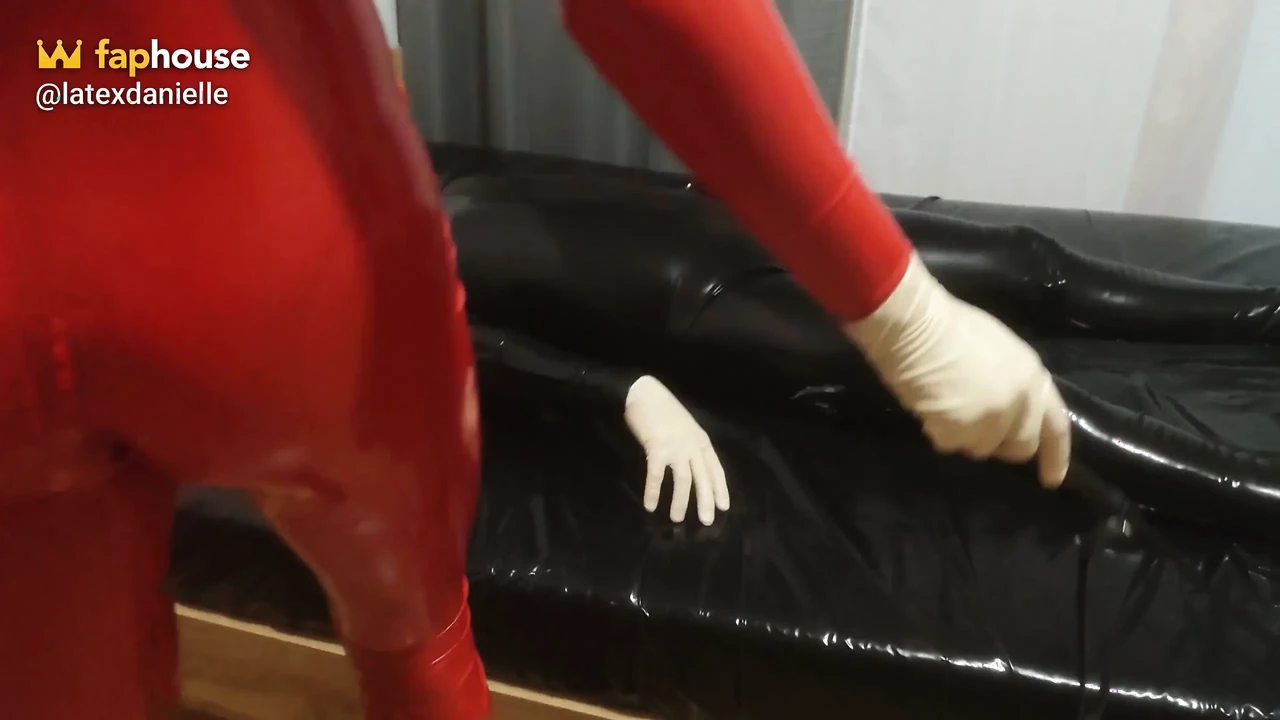 Hot MILF in a Red Latex Catsuit She Is Enjoying It with a Locked Slave. Second Angle