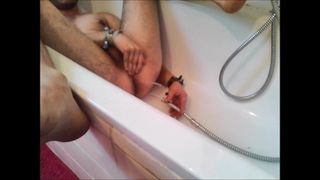 Deux mecs utilisent une pomme de douche, font jaillir de l&#39;eau, lavement