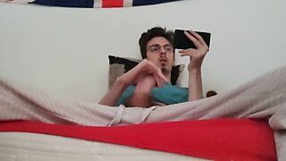 Twink masturba seu pau grande e ejacula enquanto assiste a um pornô