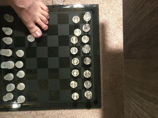 Papi spielt mit seinen Füßen Schach