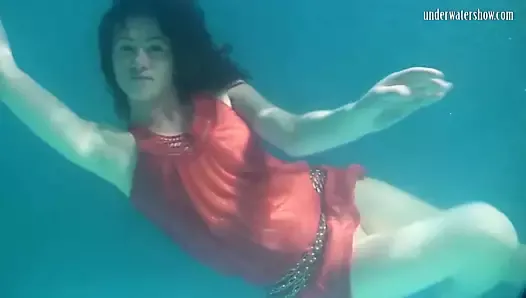 Red dressed mermaid Rusalka swimming in the pool