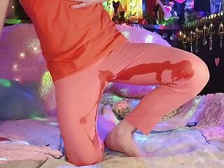 Chica trans mojandose en pantalones rojos coral y blusa