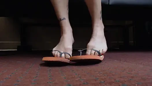 Игра с шлепантом обуви с красными ногтями крупным планом