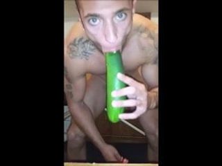 Un mec sexy joue avec un concombre devant la caméra