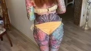 Tattoo-Modell im gelben Bikini
