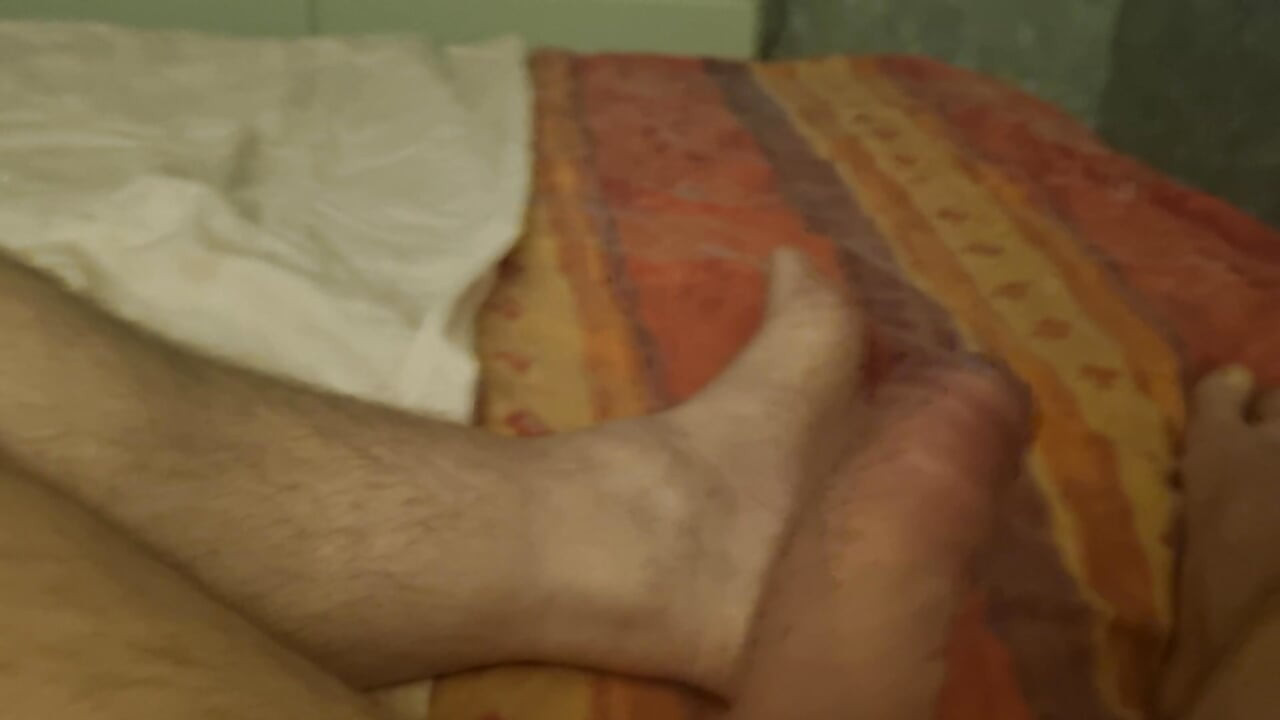 El padrastro se acuesta y le masturba la polla hasta que venga. Le encanta jugar con su polla cuando miro