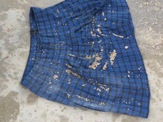 Mokra gleba na niebieskiej spódnicy w kratę