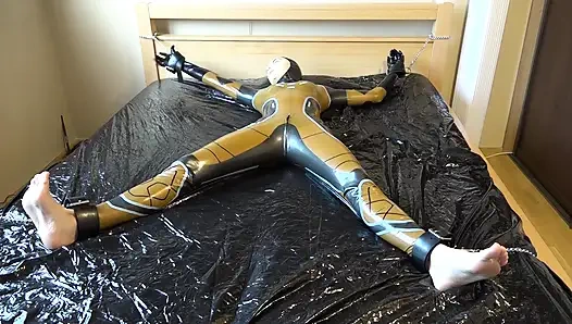 Lateks Danielle yatağa bağlı ve masaj vibratörüyle mastürbasyon yapıyor