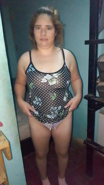 She pulls up her floral dress from the front to show us her purple thong