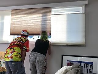 Un couple regarde devant la fenêtre de l’appartement