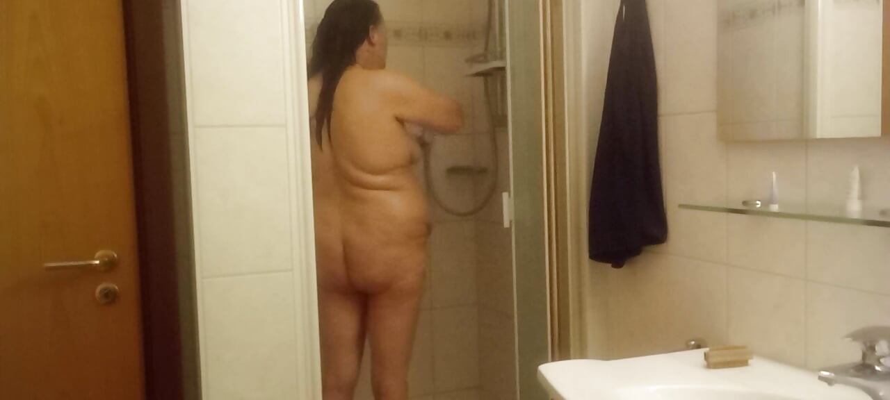 成熟的胖女人在淋浴間，大肚子看得一清二楚