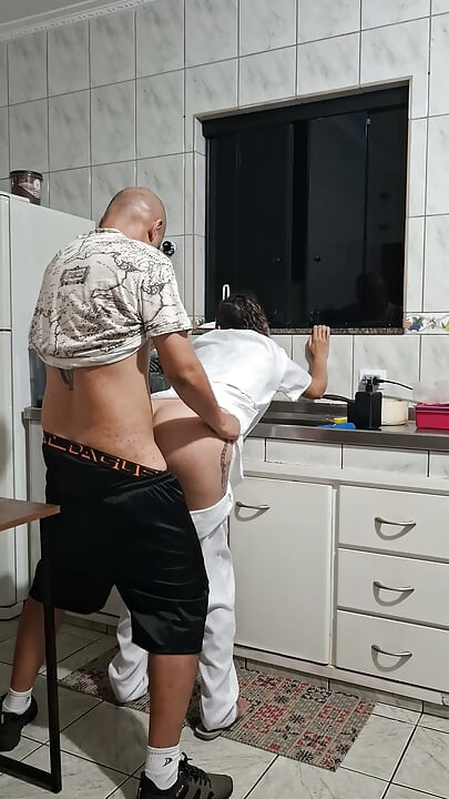 O fute pe menajeră din spate în bucătărie.