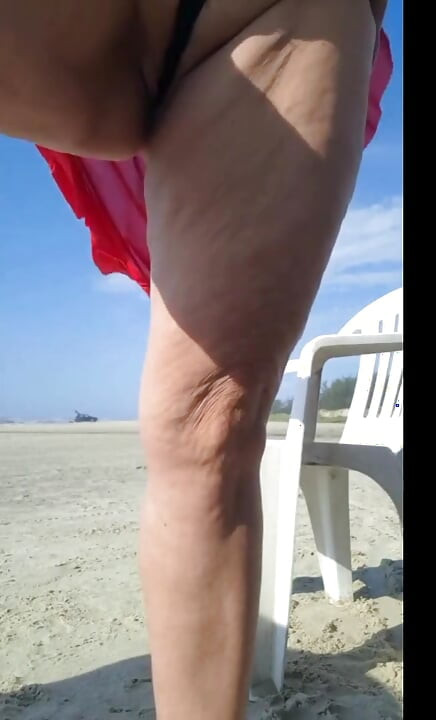 Hot crown sunbathing on the beach in transparent micro bikini