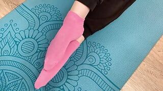 Chica fitness hace ejercicios en la estera en calcetines y le da una paja con los pies a su entrenador con semen en los pies
