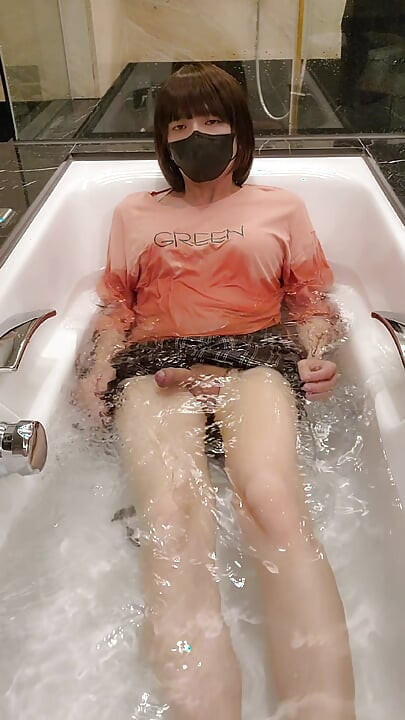 Shemale Ting xuan takes a bath in the bathtub wearing clothes