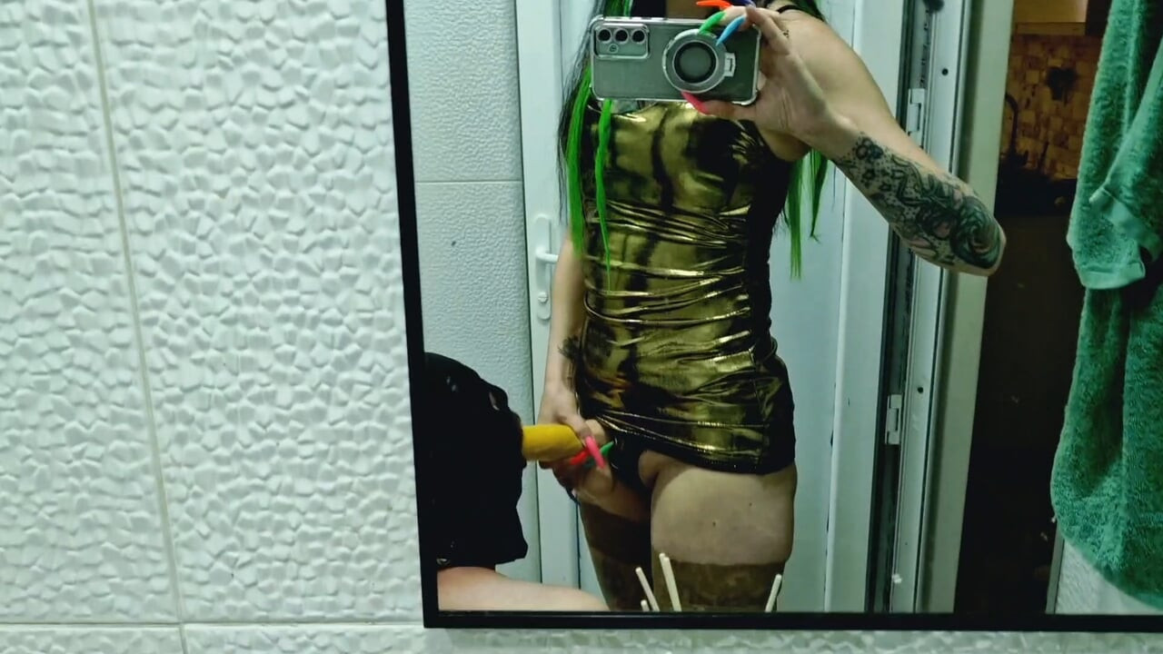 A slave is cleaning a dirty toilet when Dominatrix Nika comes to him with a strap-on and makes him take the strap-on in his mout