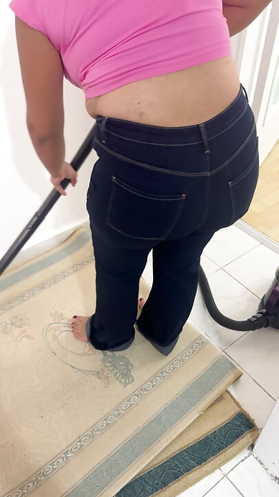 Curvy woman cleaning the house in trousers