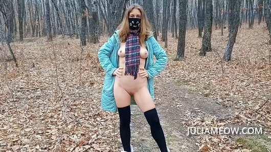 Exhibitionist girl undresses in the autumn forest